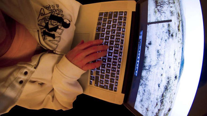 Un joven consulta Internet desde un ordenador portátil.