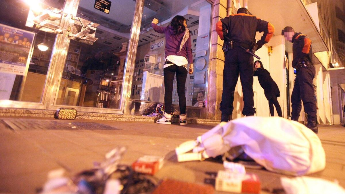 Agentes de la Ertzaintza identifican y cachean a dos jóvenes en Donostia.