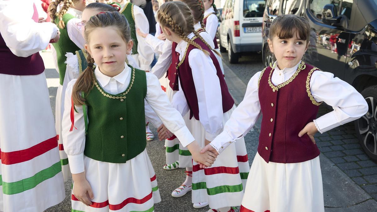 Niñas vestidas con chalecos verde y granate esperando a iniciar el desfile.