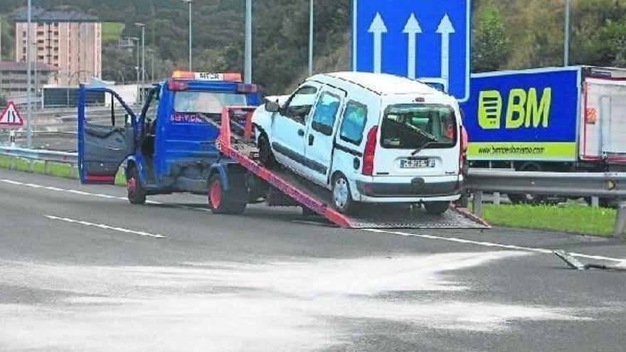 Una grúa retira la furgoneta Renault Kangoo que colisionó contra un camión en la AP-8.