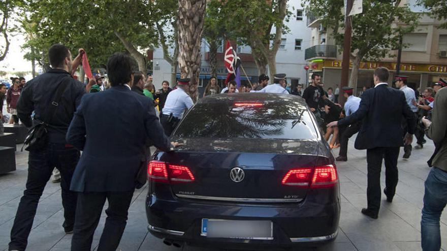 El coche del ministro de Hacienda, Cristóbal Montoro, a la salida del mitin  en Vilanova i la Geltrú donde hubo una protesta.