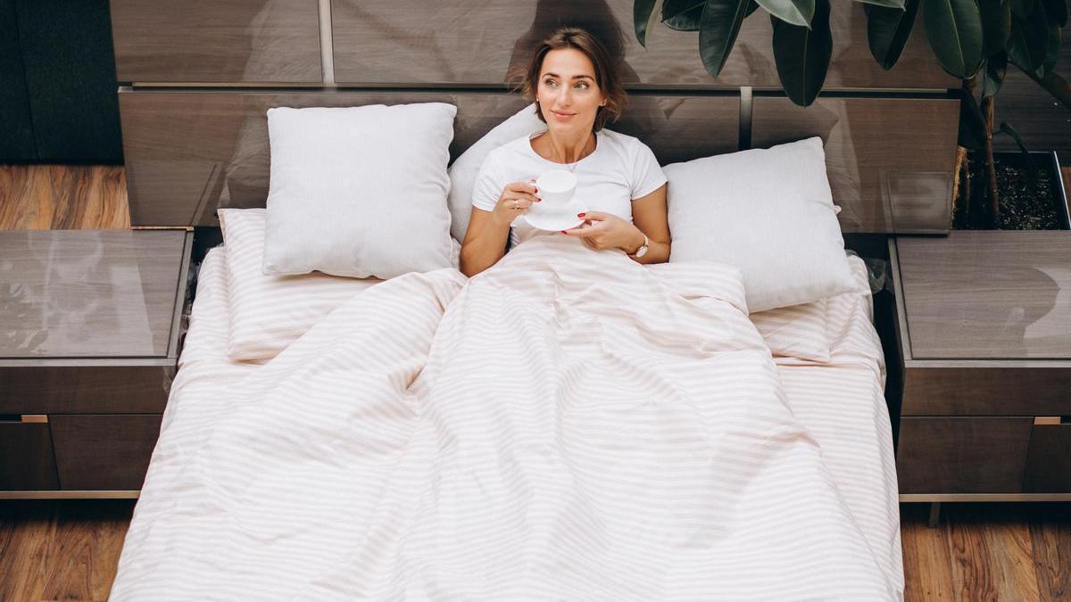 Joven mujer descansando en la cama por la mañana Joven mujer descansando en la cama por la mañana