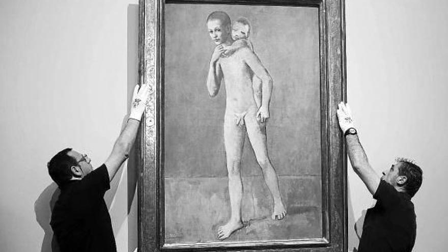 Dos operarios cuelgan la obra de Picasso en la pinacoteca.