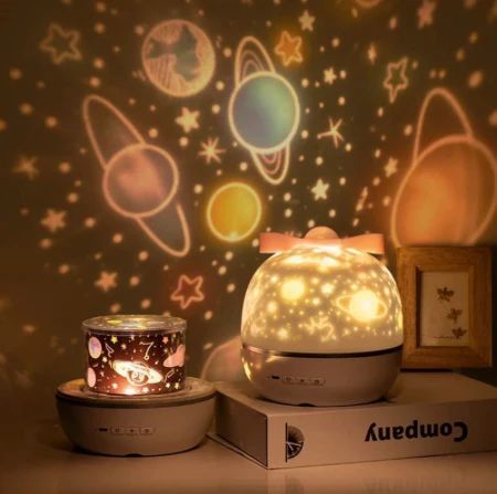Lámpara nocturna que proyecta figuras de estrellas y planetas.