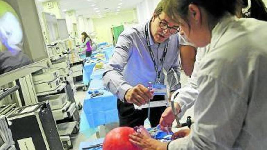 Estudiantes simulan una operación con laparoscopia a un bebé.