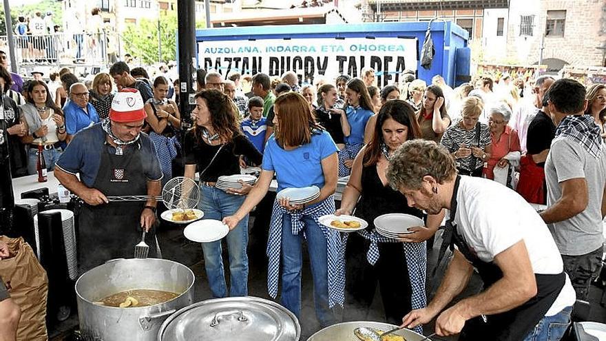 Benito Elizagoien e Iban Larratxea repartiendo baztan-zopak.