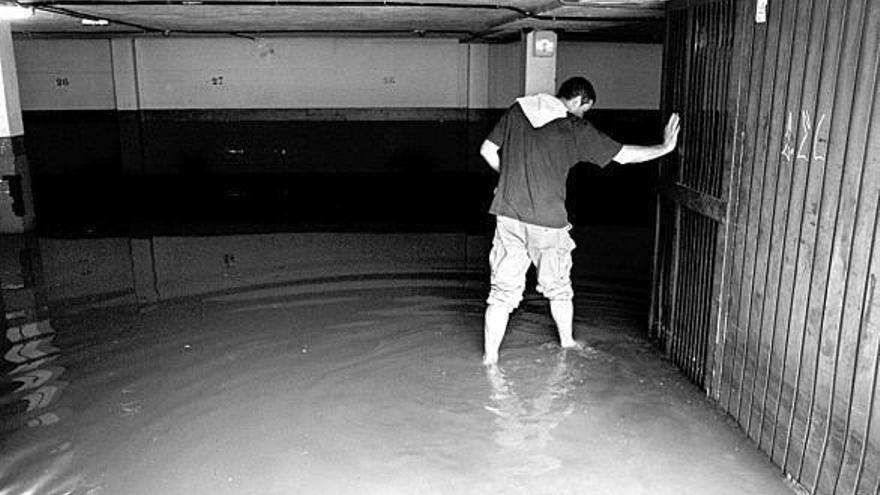 Un vecino de Zizur Mayor abre la puerta de su garaje, inundado tras las fuertes lluvias.