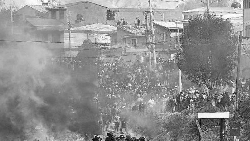 Militares y policías bolivianos se enfrentan a cientos de manifestantes en Cochabamba, Bolivia.