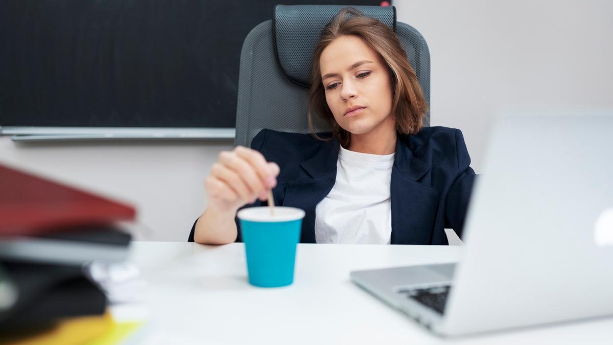 Una mujer revuelve un café con desgana. Una mujer revuelve un café con desgana.