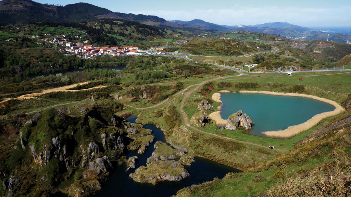 Al fondo, el poblado minero de la Arboleda y antiguos pozos que se han convertido en estanques.