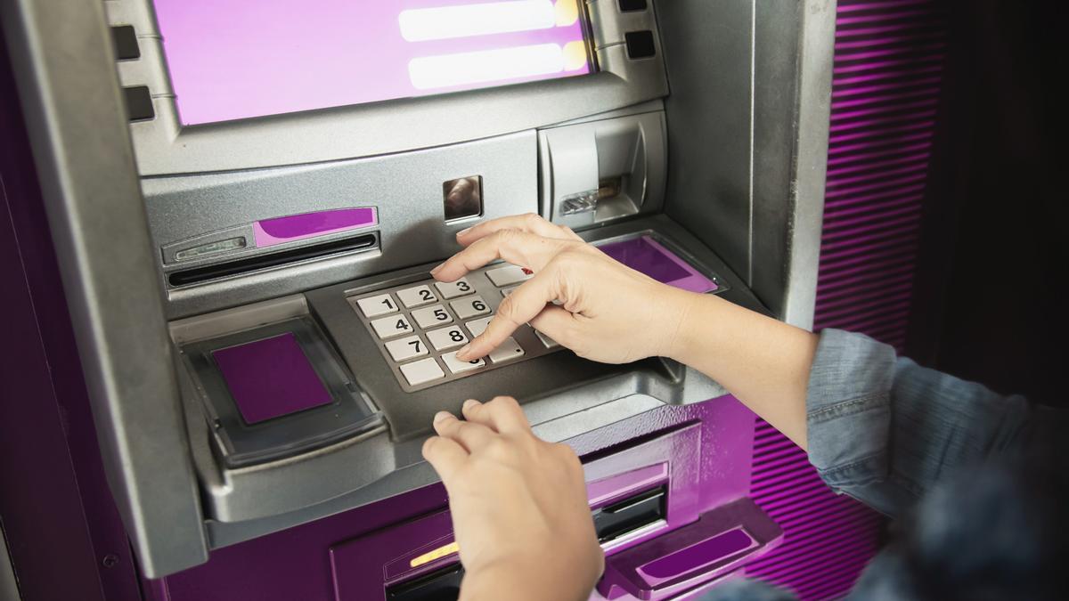 Una mujer teclea el número PIN de su tarjeta en un cajero automático.