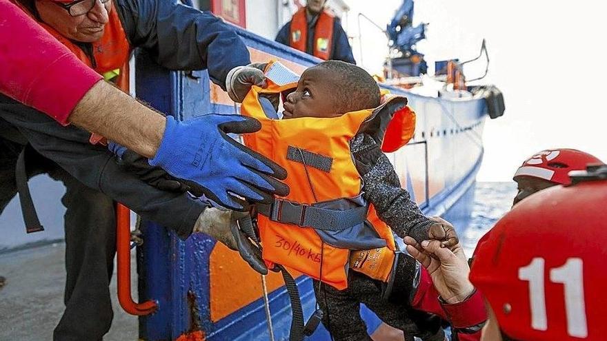 Un miembro de la tripulación del ‘Aita Mari’ rescata a uno de los bebés que viajaba en la patera.