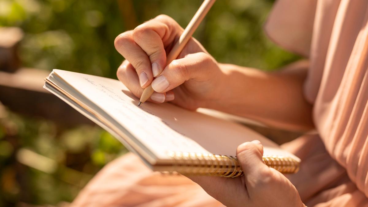 Una persona escribe a mano en su cuaderno