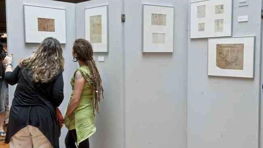 Dos mujeres admiran una de las ilustraciones incluidas en la exposición que alberga la biblioteca foral de Bilbao.