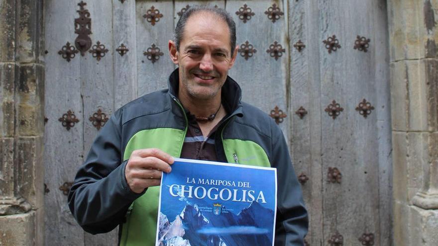 Un sonriente Patxi Goñi posa en su calle de Lumbier, la Abadía, con el cartel de su último viaje y expedición al Chogolisa.