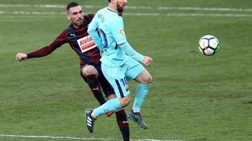 El delantero argentino del FC Barcelona, Lionel Messi, pelea el balón frente al defensa del Eibar, Anaitz Arbilla.