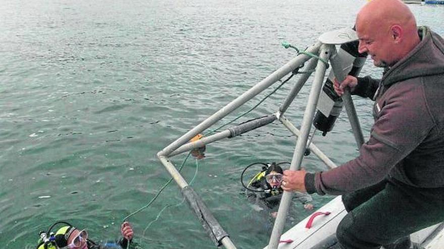 Técnicos y submarinistas sumergen un sensor multiparamétrico frente a la playa de Toña.