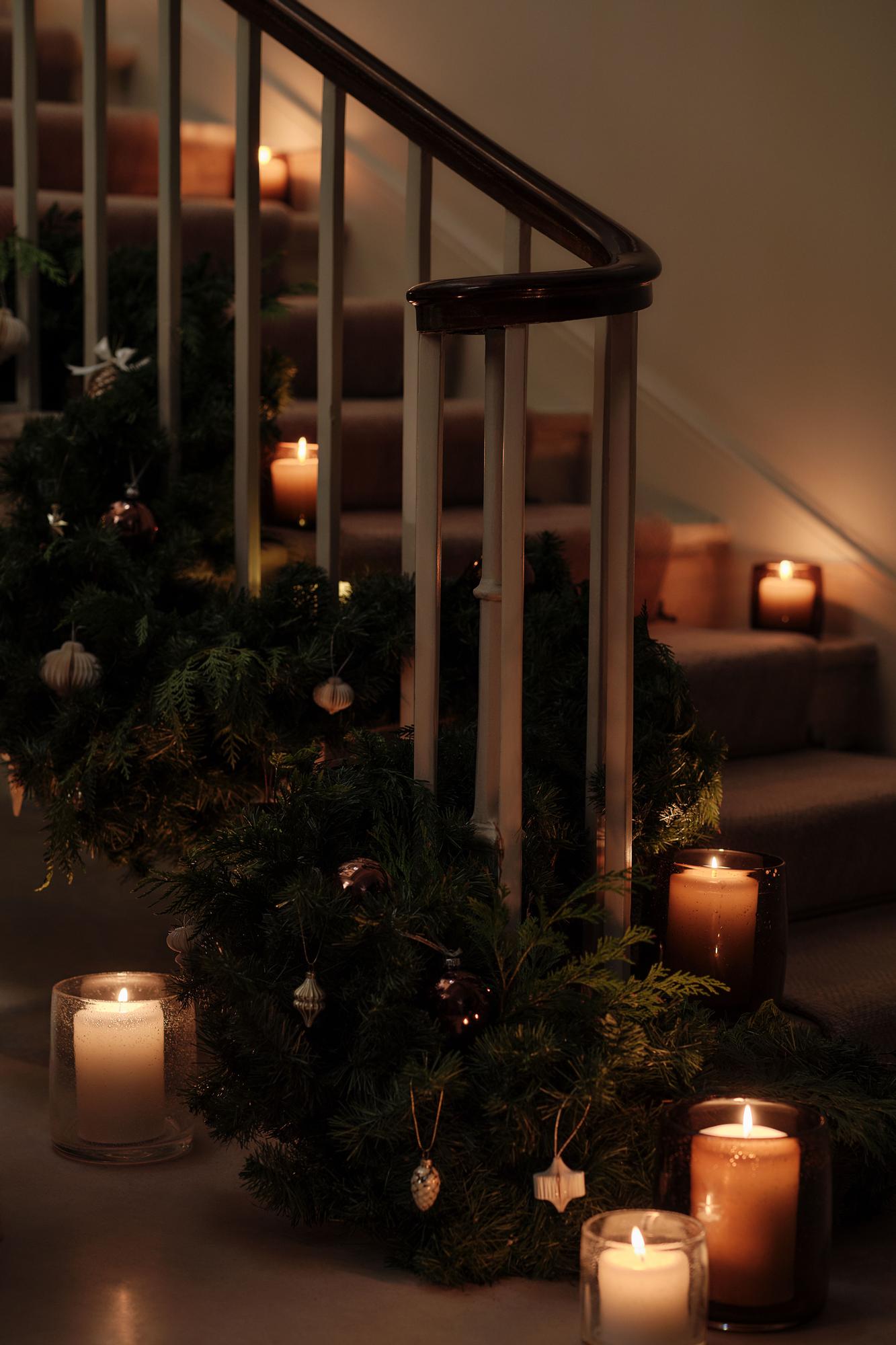 Escalera decorada con velas y guirnaldas.