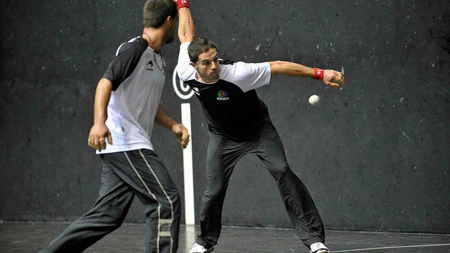 Aimar Olaizola, golpeando la pelota durante la prueba-entrenamiento en el frontón Bizkaia, ante la mirada de Bengoetxea VI.