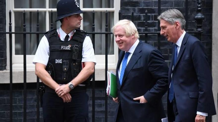 El primer ministro británico, Boris Johnson, acompañado del exministro de Economía y Hacienda británico Philip Hammond, en el 10 de Downing Street, Londres.