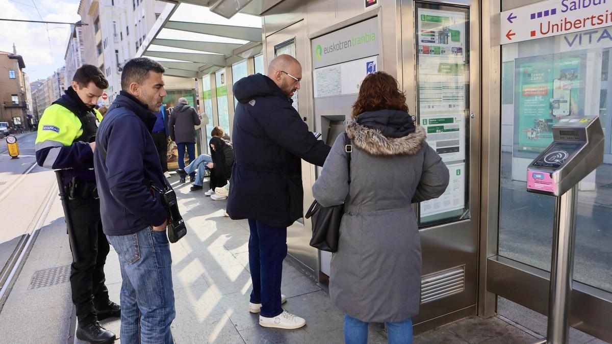 Gente haciendo uso de la tarjeta BAT en las marquesinas del tranvía de Vitoria