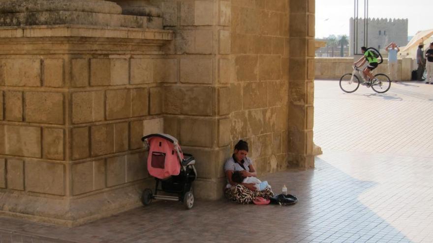 Una madre y su hija pequeña piden en una calle de España.