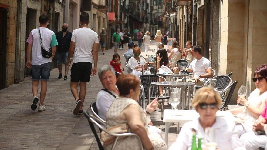 Varias personas tomando algo en una terraza.