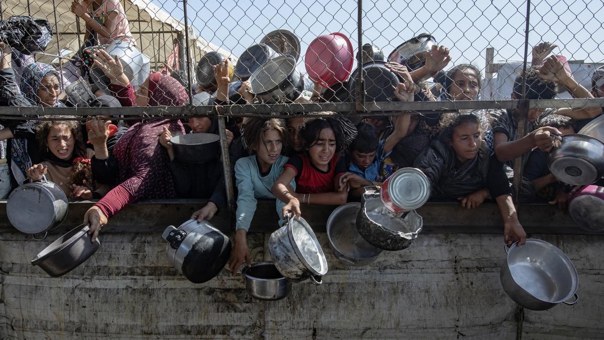 Palestinos desplazados internos se amontonan para recibir raciones limitadas en medio de la escasez de alimentos en Jan Yunis, al sur de la Franja de Gaza.