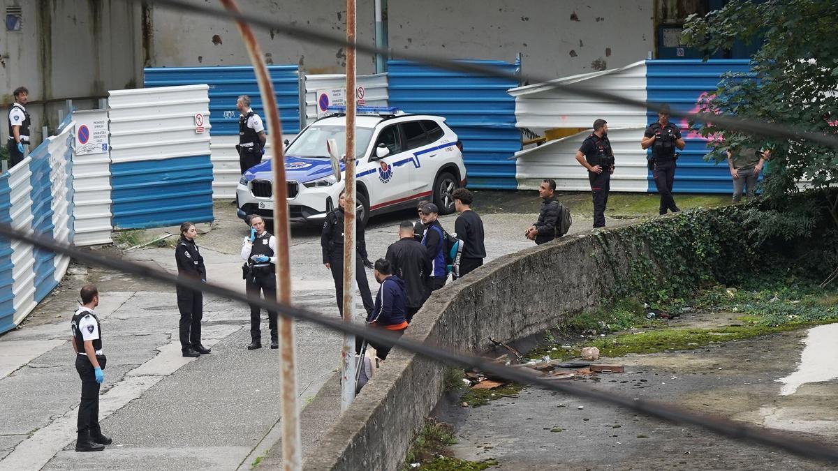Agentes de la Ertzaintza y de la Guardia Muncipal junto a moradores de los pabellones en desuso, durante la actuación policial desplegada el jueves en Herrera.