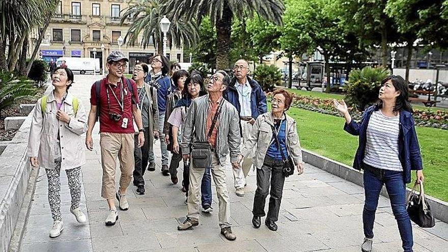 Una guía japonesa muestra a sus compatriotas las huellas de la Guerra Civil en el hotel María Cristina.