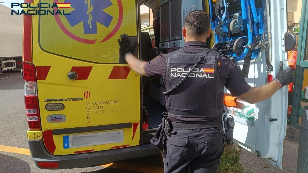 Un policía junto a una ambulancia