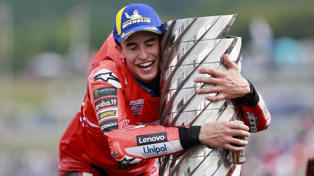 Marc Márquez se abraza al trofeo de campeones mundiales de la categoría reina.