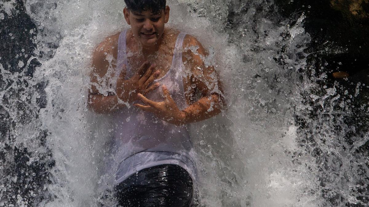 Un joven se baña en el río.