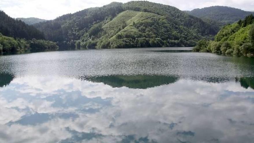 Vista general del embalse Ibai Eder de Nuarbe, con las nubes del cielo reflejadas en el agua