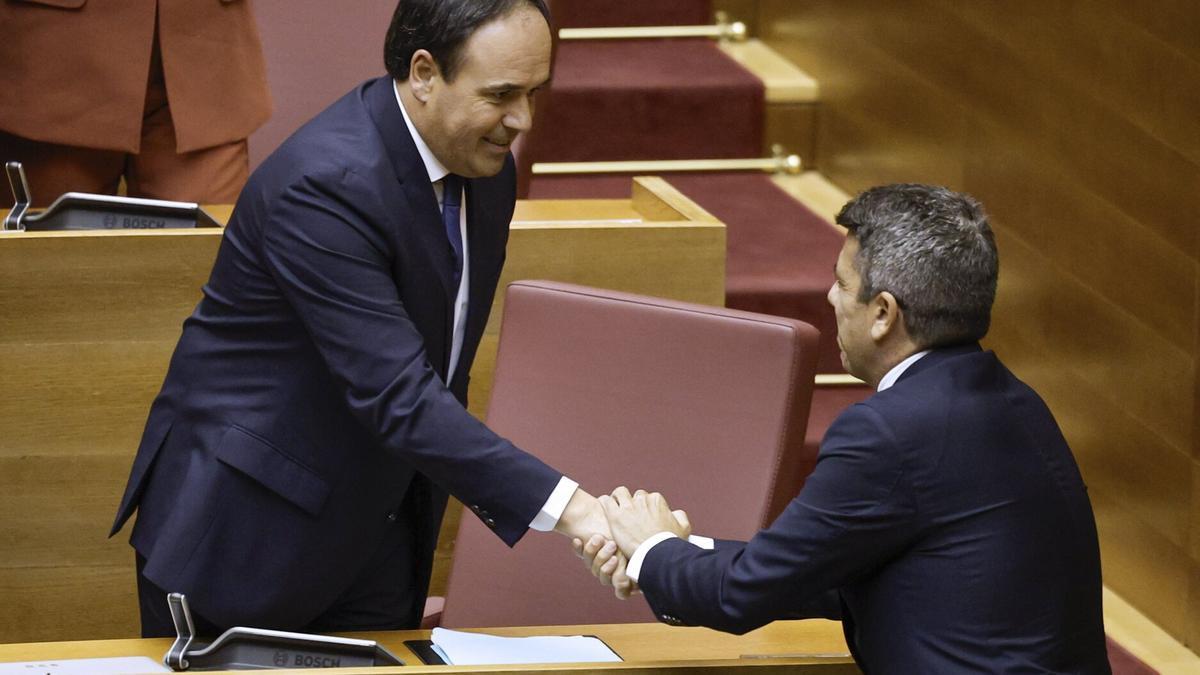 El ya expresident de la Generalitat Carlos Mazón (d) felicita al nuevo president, el secretario general del Partido Popular en la Comunitat Valenciana, Juanfran Pérez Llorca.