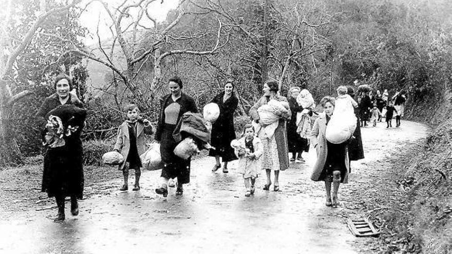 Mujeres y niños tratan de huir de la Guerra Civil con sus enseres.