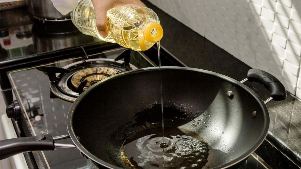 Un cocinero vierte aceite de girasol antes de cocinar.