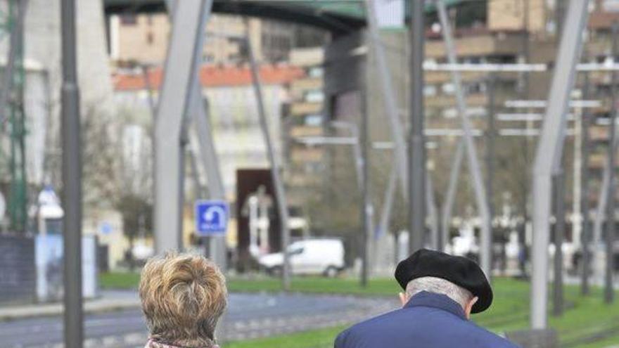 Dos personas mayores pasean por Bilbao.