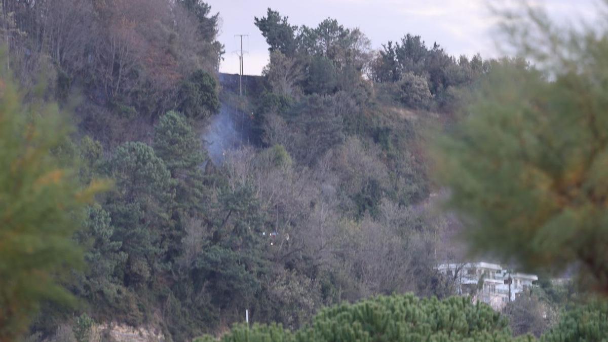 Humo en la zona afectada por un incendio, encima de las casas de Interlimen, en la subida al faro de Hondarribia