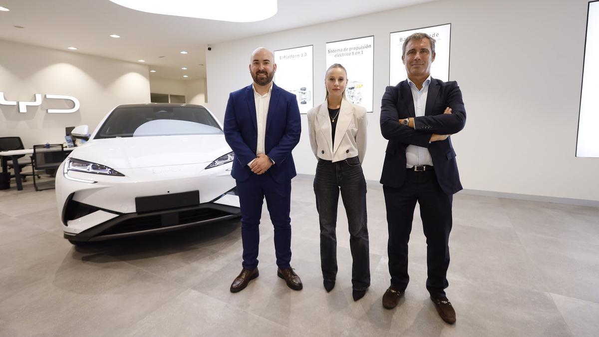 Borja García, jefe de ventas, Sara Veiga, comercial, y Carlos Higuera, gerente, posan ante el nuevo Seal 6 DM-i.