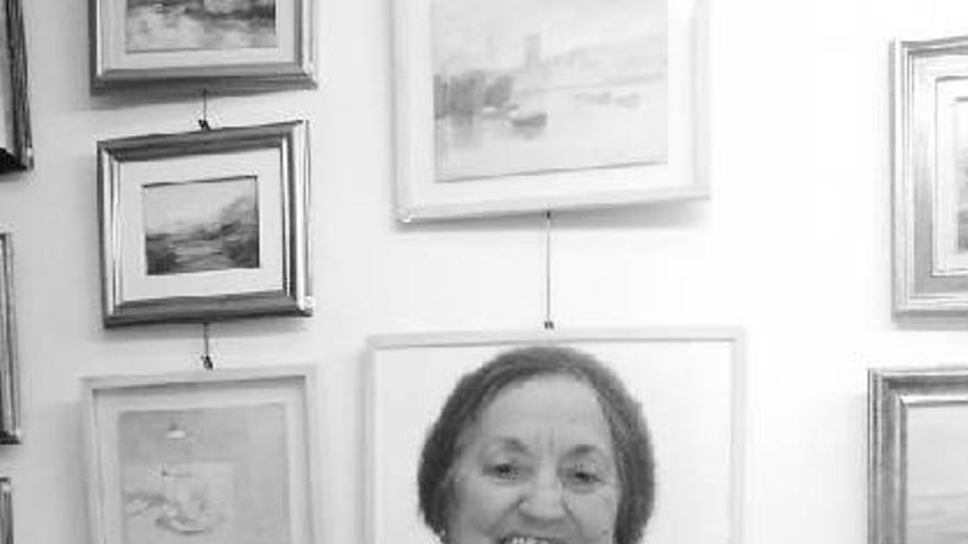 Conchi Pascua posa junto a algunas de las obras expuestas en la galería Movellán.