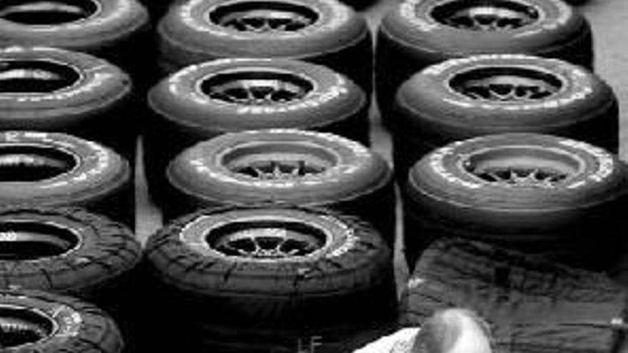 Un mecánico de McLaren inspecciona neumáticos Bridgestone.