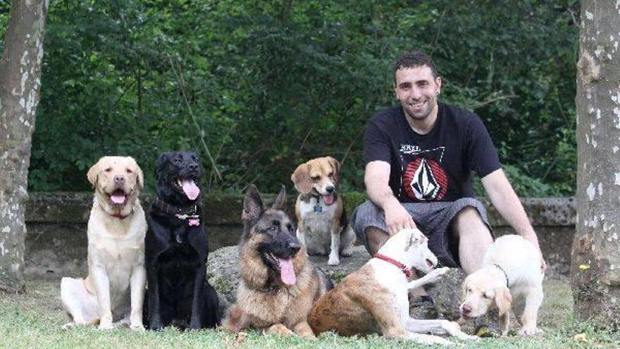 Fran Beato posa junto a seis perros en una zona verde del barrio Sallobente-Ermuaran, en Elgoibar.