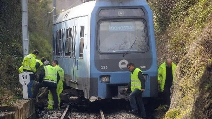 Varios operarios trabajan ayer ante el tren descarrilado.