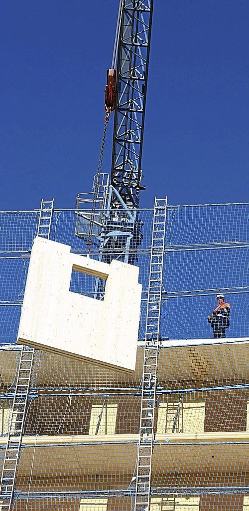 Colocación de material contralaminado de madera durante las obras de construcción industrializada en un edificio en Navarra. 