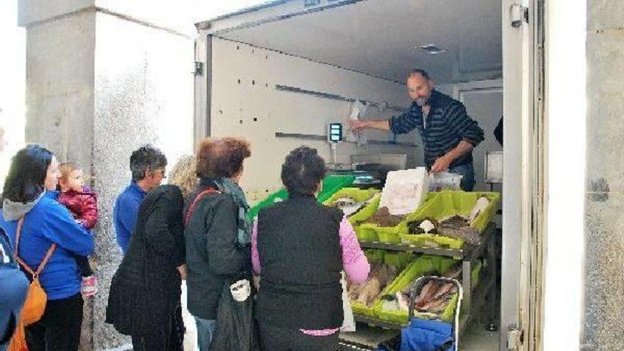 Guillermo y Bingen atendiendo ayer a la clientela desde su camioneta, aparcada en la plaza de Berastegi.