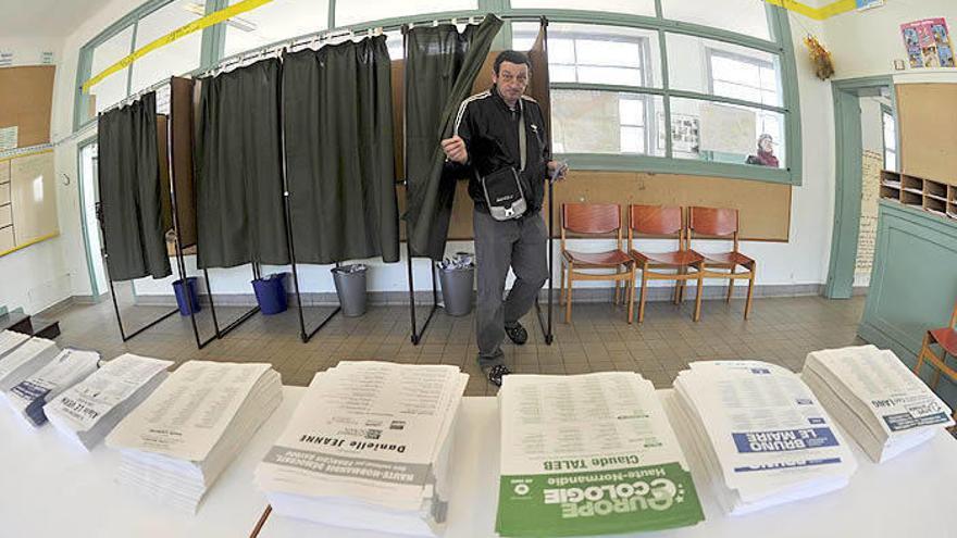 Herritar bat Frantzia hegoaldeko herri bateko hautesleku batean bozka egiterako orduan .