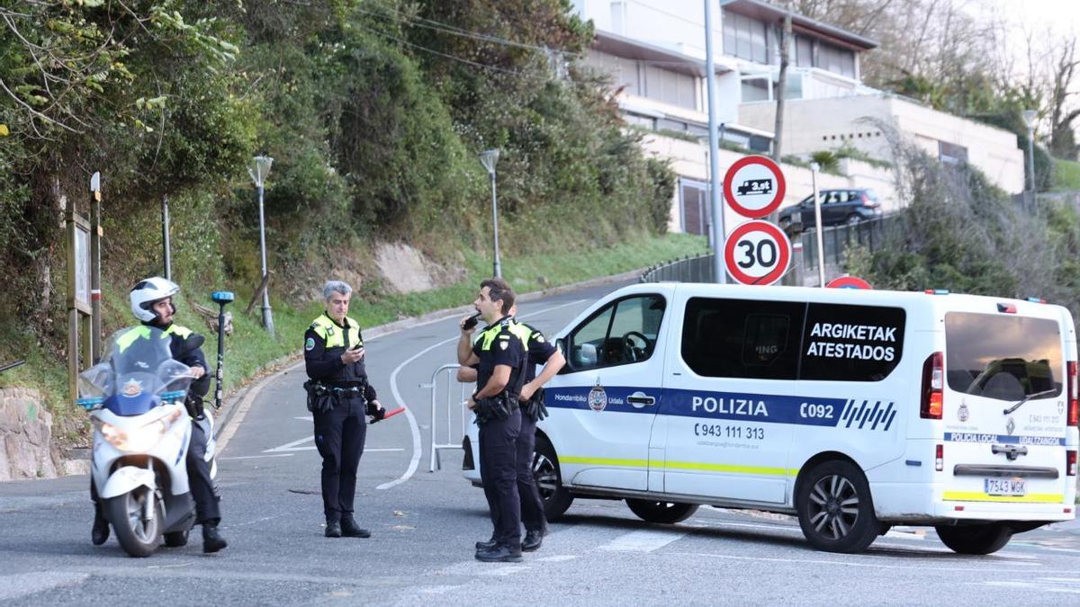 La Policía Municipal, junto al cartel que impide el acceso a la carretera del faro de Hondarribia