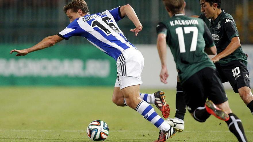 El centrocampista de la Real Sociedad Sergio Canales (i) pelea un balón con los jugadores del Krasnodar, Vitali Kaleshin (c) y Odil Ahmedov durante el partido de vuelta.