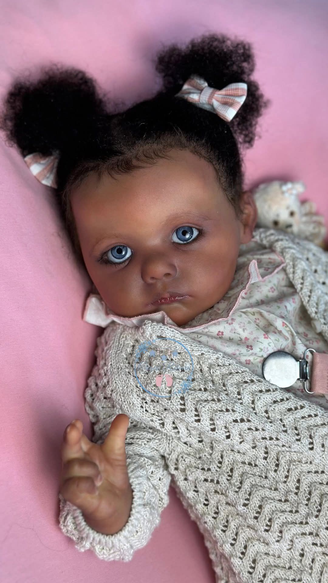 Una muñeca reborn tumbada sobre una manta